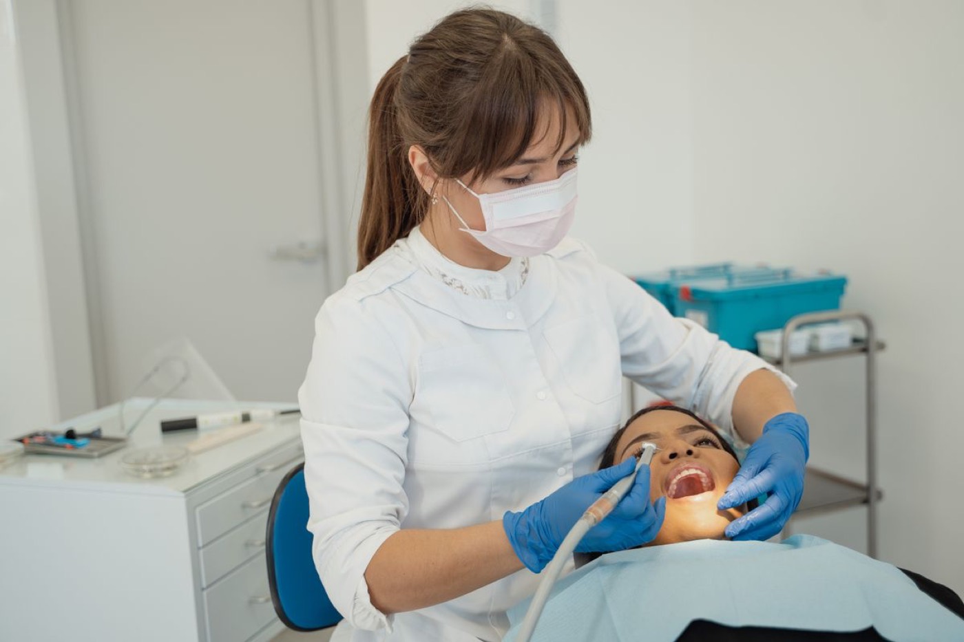 A periodontist treating a patient in a bright clinical treatment room